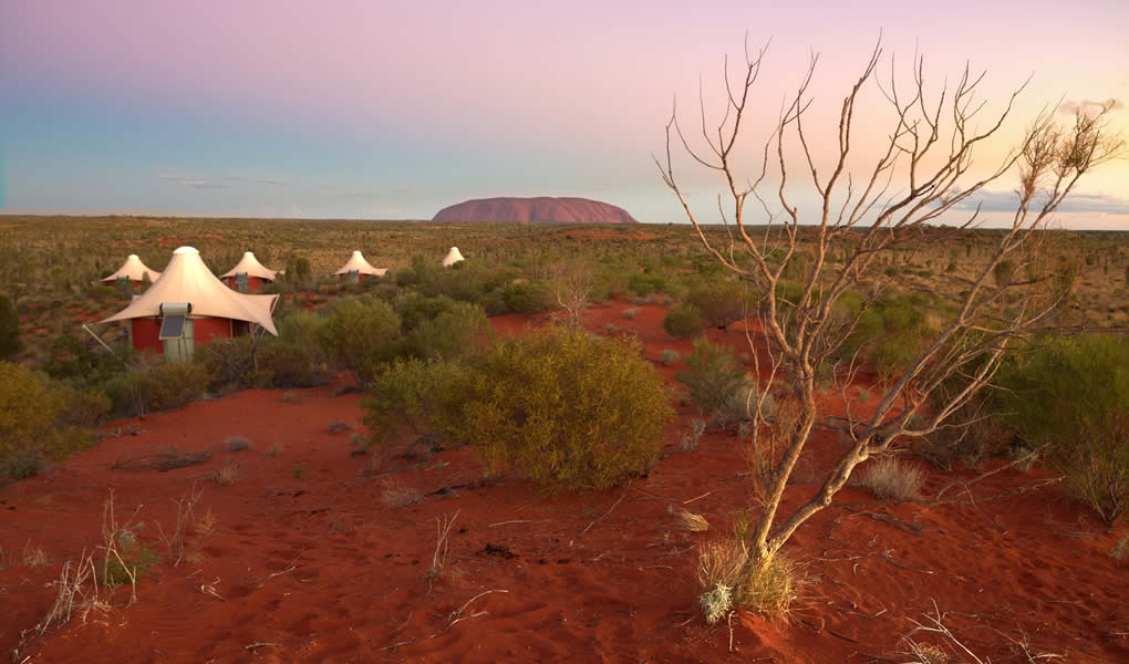 Tiendas del lodge lujo Longitude 131 al atardecer en el desierto de Australia 