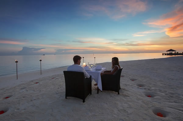 Cena romántica en la playa al atardecer en el hotel Velassaru