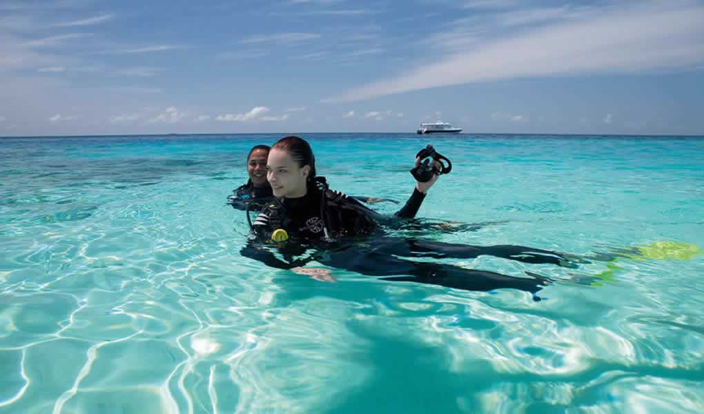 Mujer haciendo snorkel en el mar Maldivas hotel Constance Moofushi