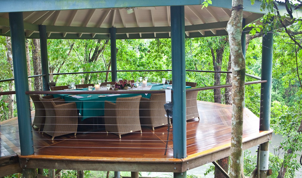 Mesas madera en Treehouse Restaurant en Lodge lujo Silky Oaks Lodge Australia