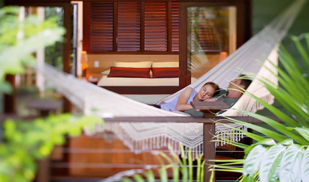 Pareja descansando en terraza Treehouse Restaurant en medio naturaleza en Silky Oaks Lodge Australia