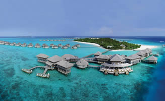 Imagen desde aire hotel en Maldivas y sus villas overwater sobre el agua en tonos azules. 