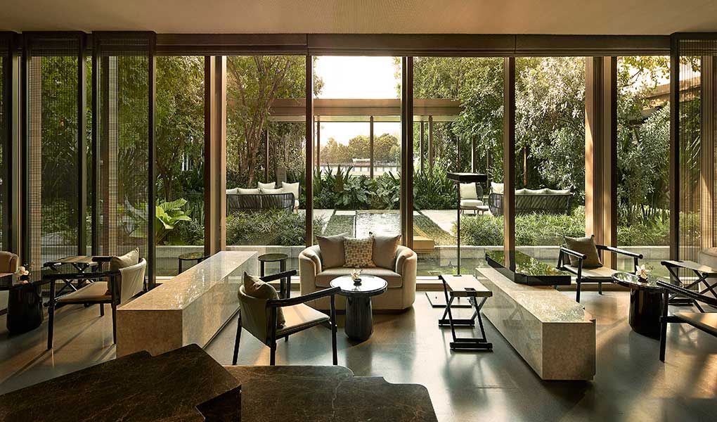 Salón interior del hotel con ventanas exteriores y vistas al jardín