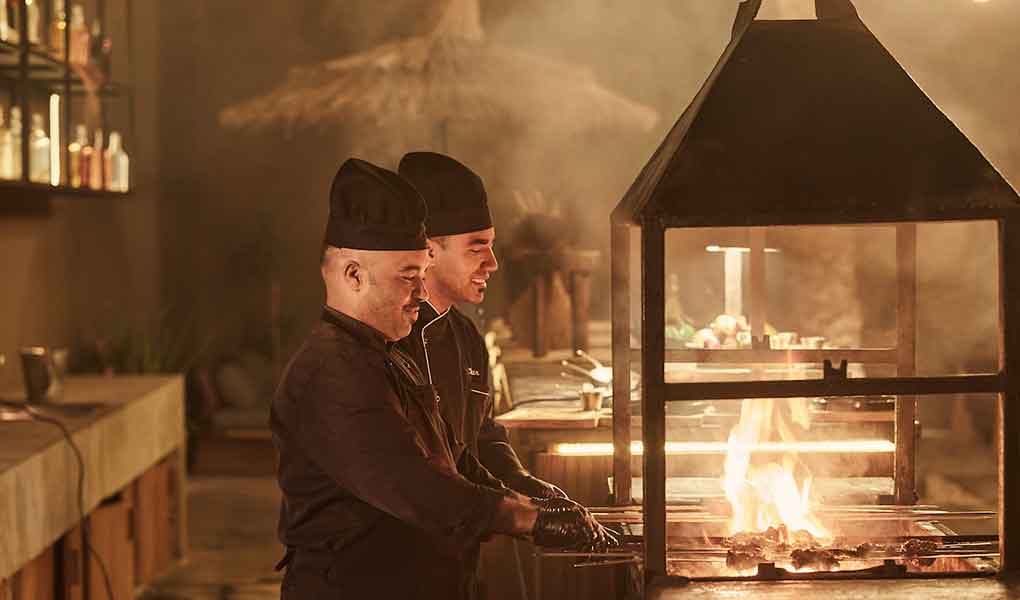 Cocineros del hotel trabajando en cena sobre la playa