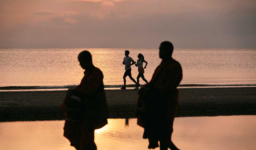 Personas realizando ejercicio en la playa al atardecer en Hua Hin