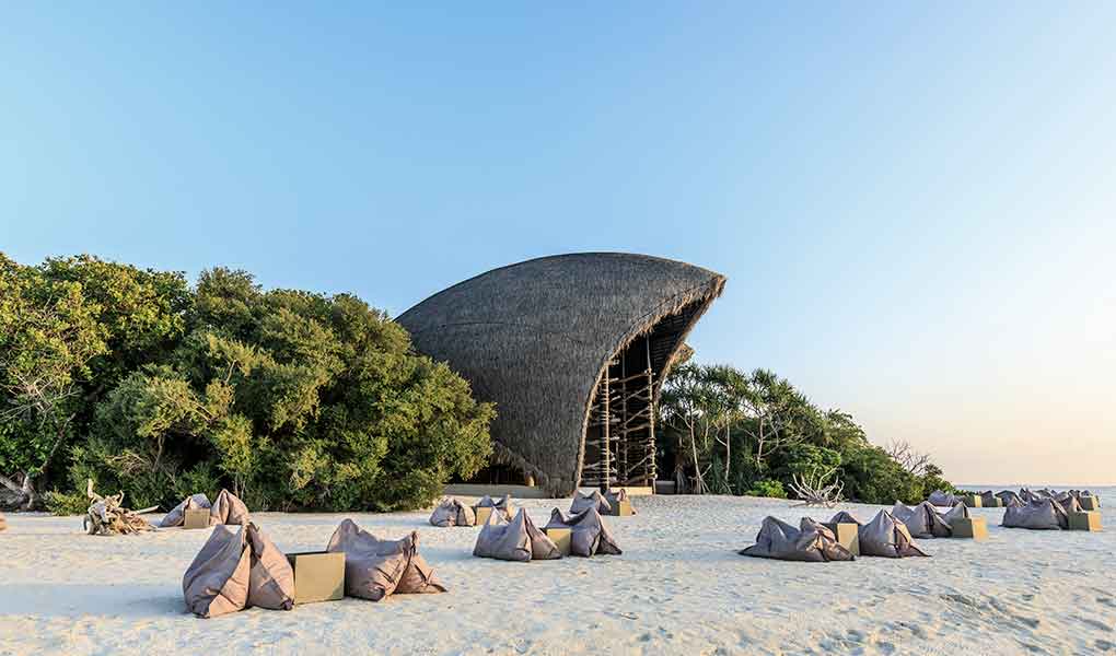 Playa del hotel con vistas al atardecer en Maldivas