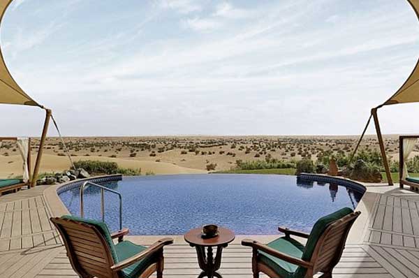 Vistas a la piscina infinita con el desierto Dubai de fondo