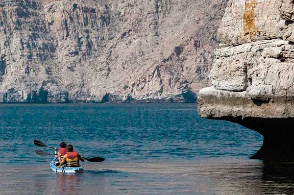 Personas haciendo kayak en Oman en resort Six Senses Zighy Bay