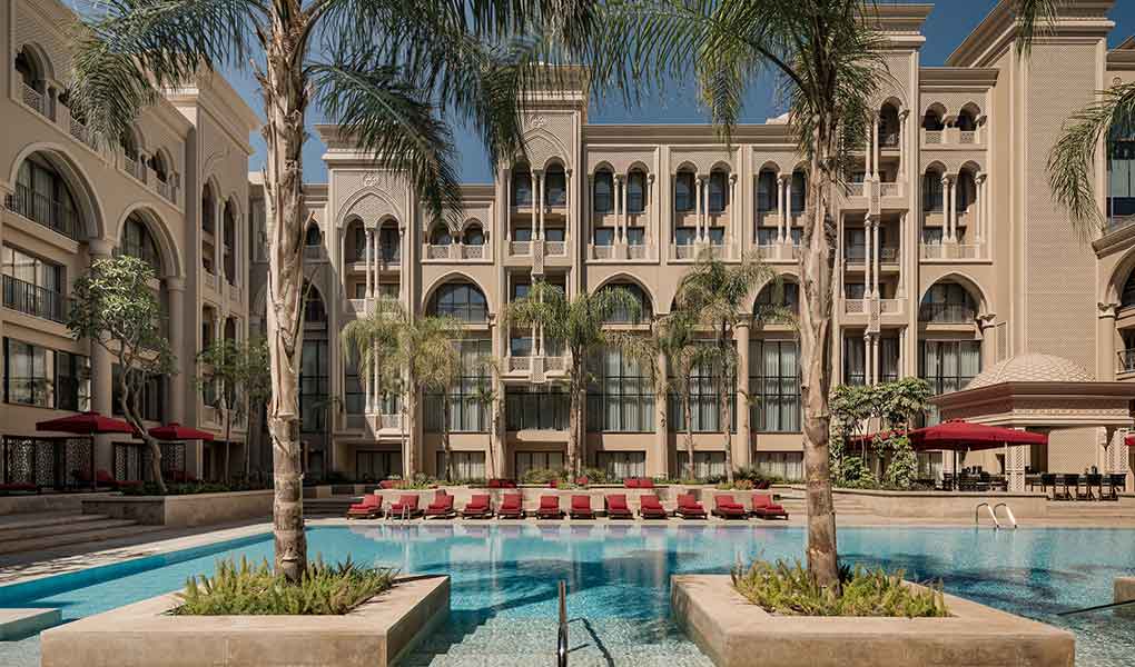 Piscina exterior del hotel con fachada de fondo