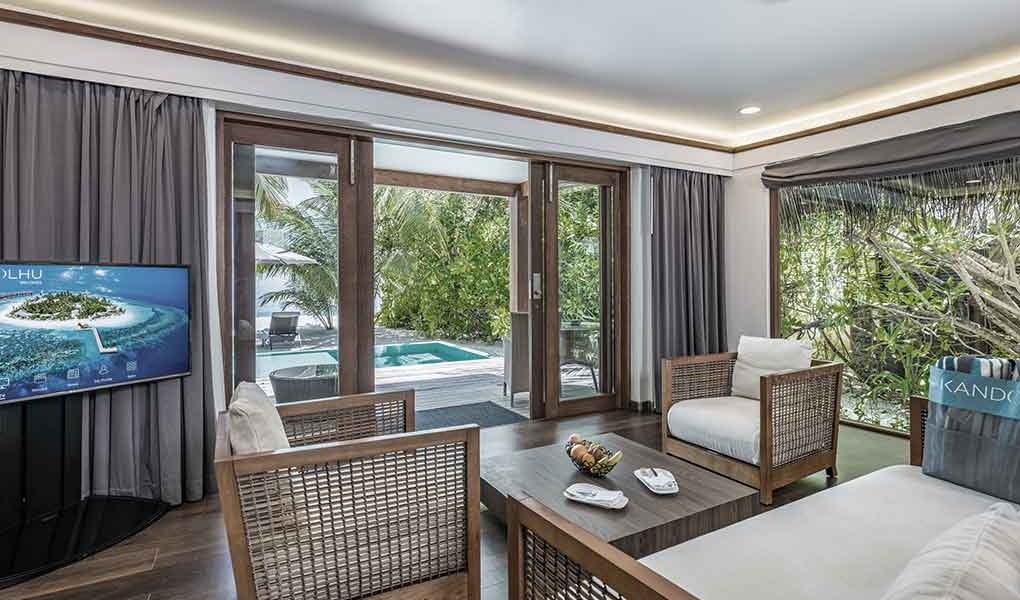 Salón de la villa con vistas a la piscina y mar en Maldivas