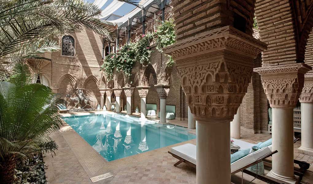 Patio tradicional interior hotel de lujo en Marruecos con piscina y palmeras