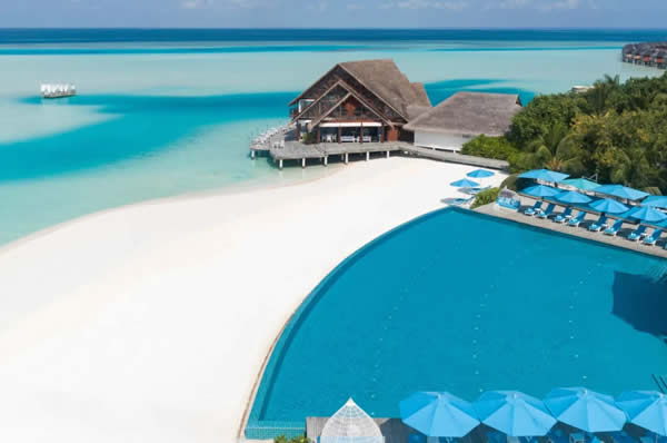 Vista del hotel Anantara Dhigu aérea piscina común, playa arena blanca y mar de fondo en Maldivas
