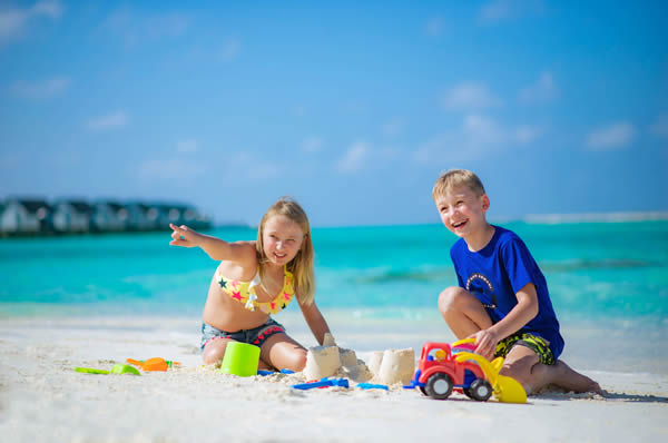 Niños jugando playa en Maldivas hotel Ozen Life Maadhoo