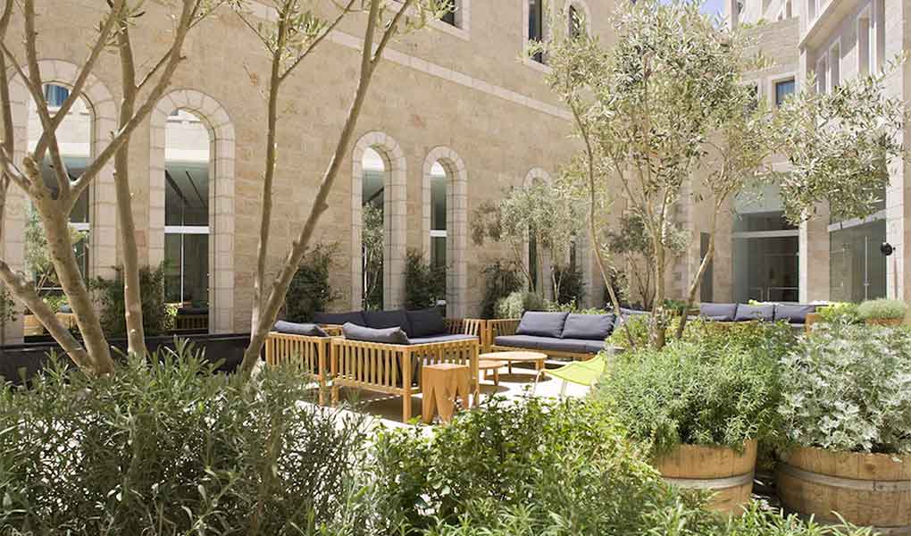 Patio interior del Mamilla Hotel con olivos en Jerusalén