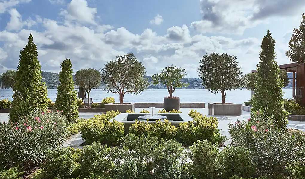 Jardines interiores del hotel Mandarin Oriental Bosphorus con el Bósforo de fondo.