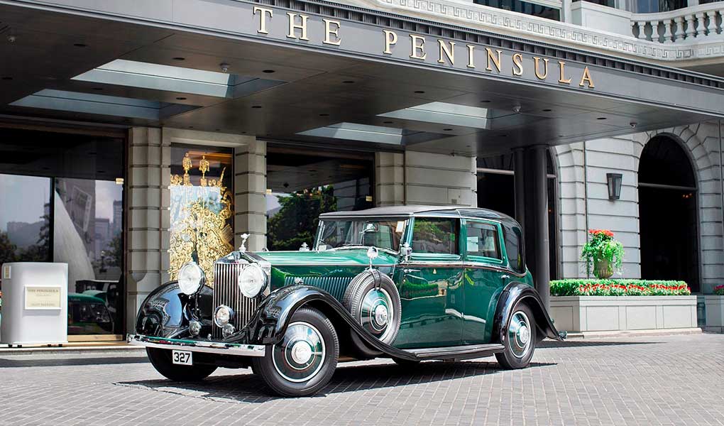 Coche verde en la entrada del hotel lujo The Peninsula Hong Kong