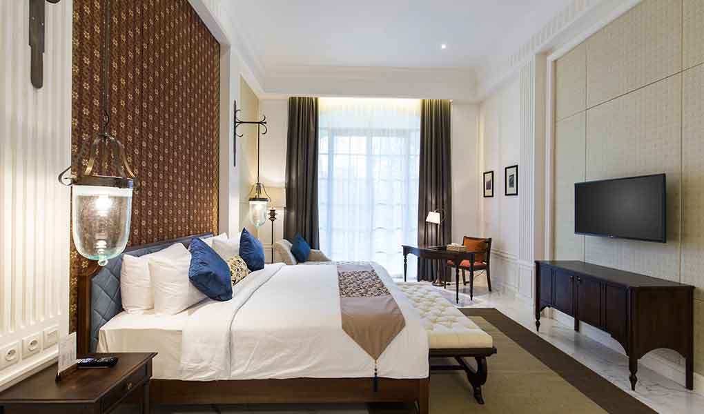 Habitación con decoración colonial en tonos blancos y madera