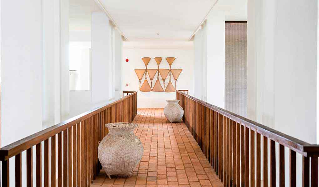 Pasillo interior con madera y paredes blancas del hotel