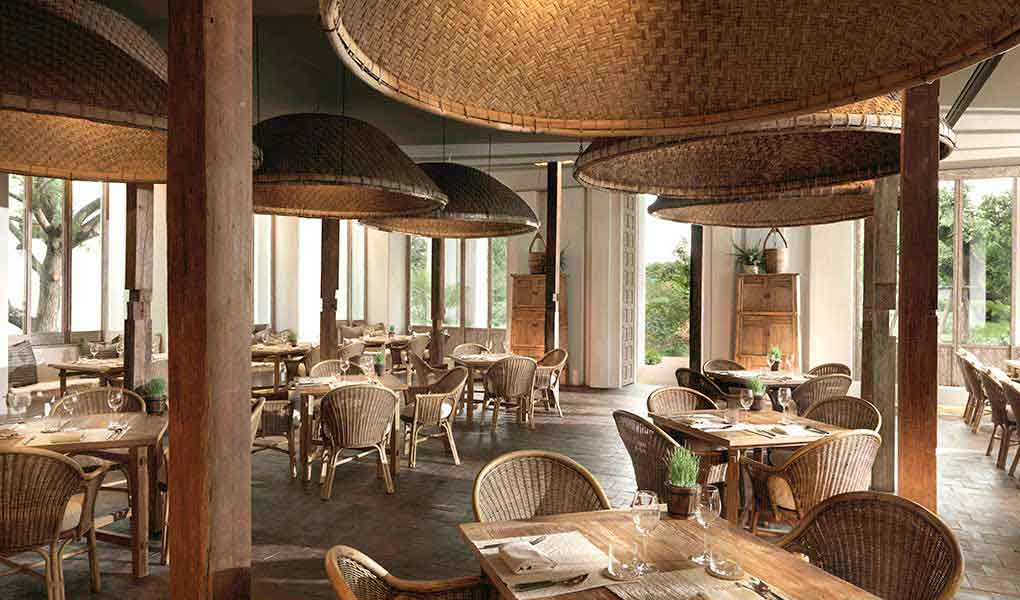 Interior del restaurante con decoración en madera hotel Raya Heritage en Tailandia