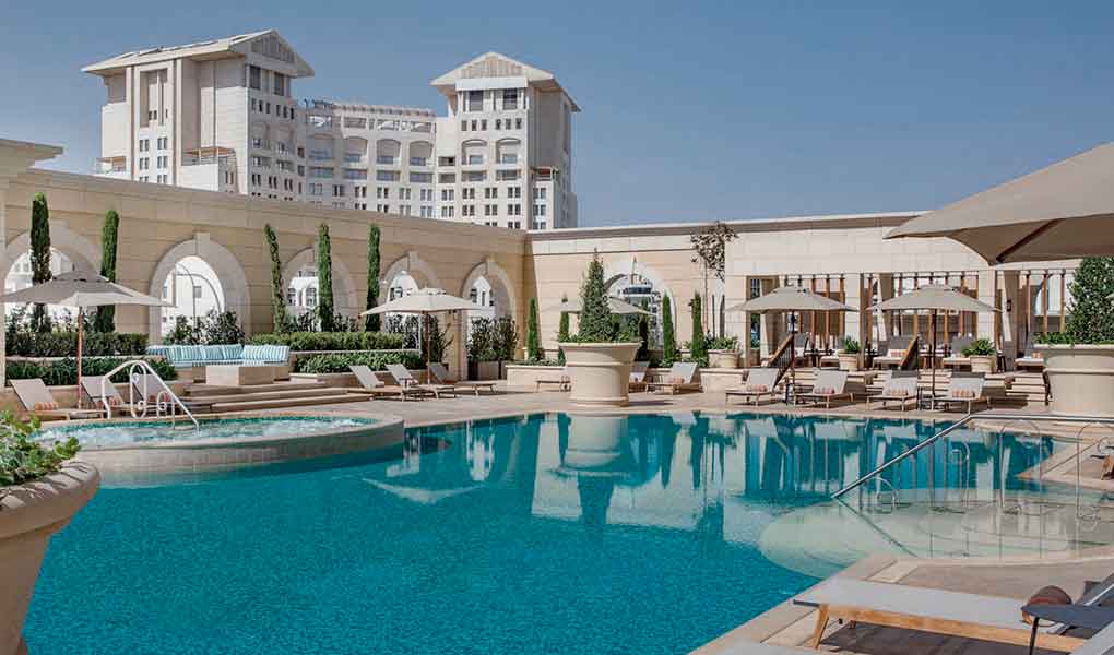 Piscina exterior del hotel con detalles en piedra en Amman