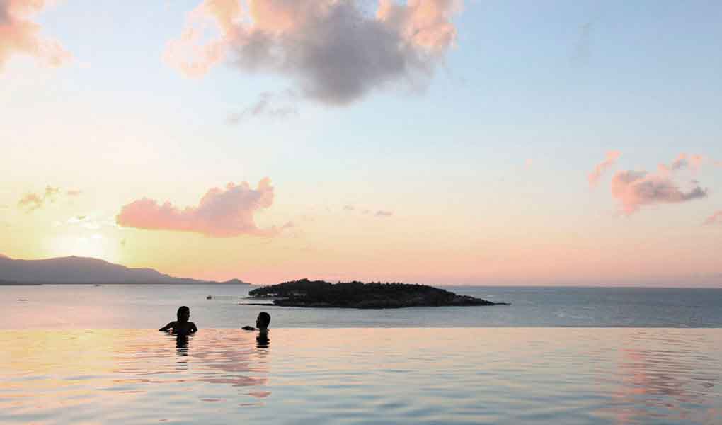 Pareja al atardecer en piscina Six Senses Samui en Tailandia