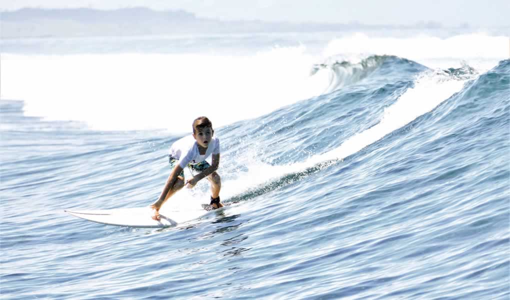 Una persona particando surf en al mar