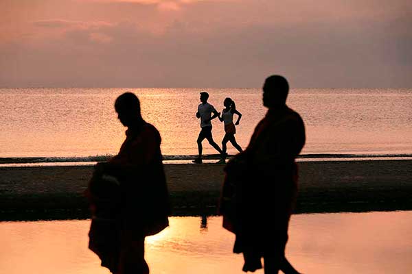 Atardecer sobre la playa y personas haciendo ejercicio en Hua Hin Tailandia