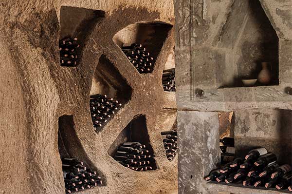 Paredes de piedra con botellas de vino en una bodega de Capadocia 