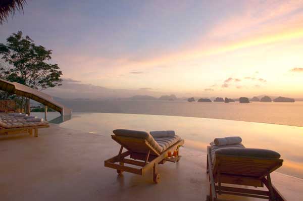 Dos tumbonas junto a una piscina infinita al atardecer Tailandia 