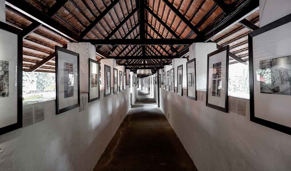 Pasillo interior del hotel con cuadros y suelos en madera de teca