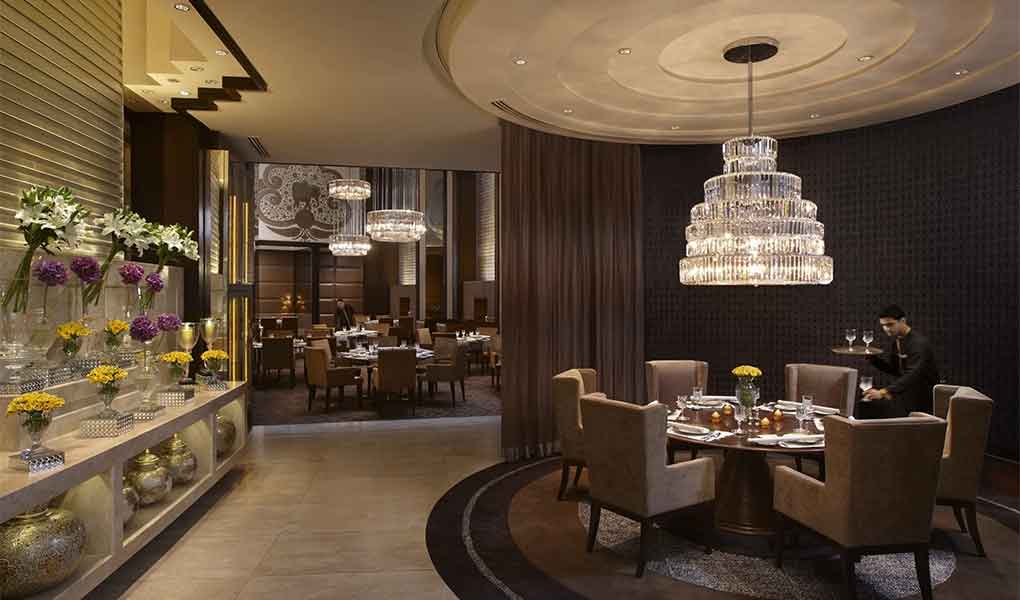 Restaurante del hotel con decoración nocturna y mesa central madera