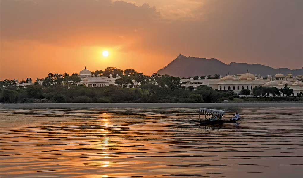 Lago Pichola al atardecer con fonde el hotel de lujo The Oberoi Udaivilas en Udaipur