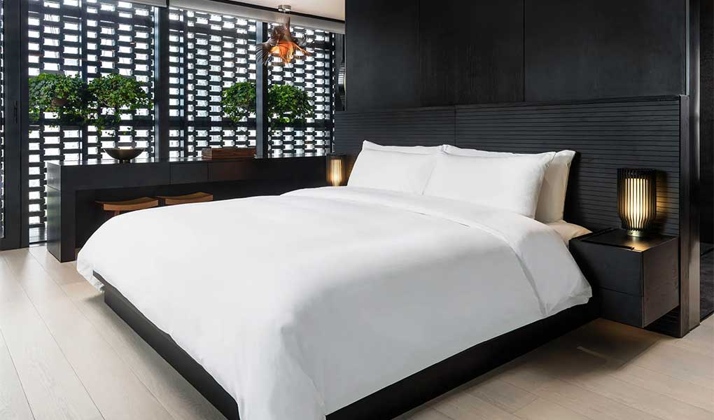 Habitación del hotel cama central en blanco detalles en madera