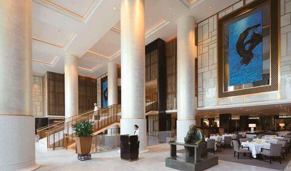 Recepción del hotel con columnas de mármol y arte tradicional