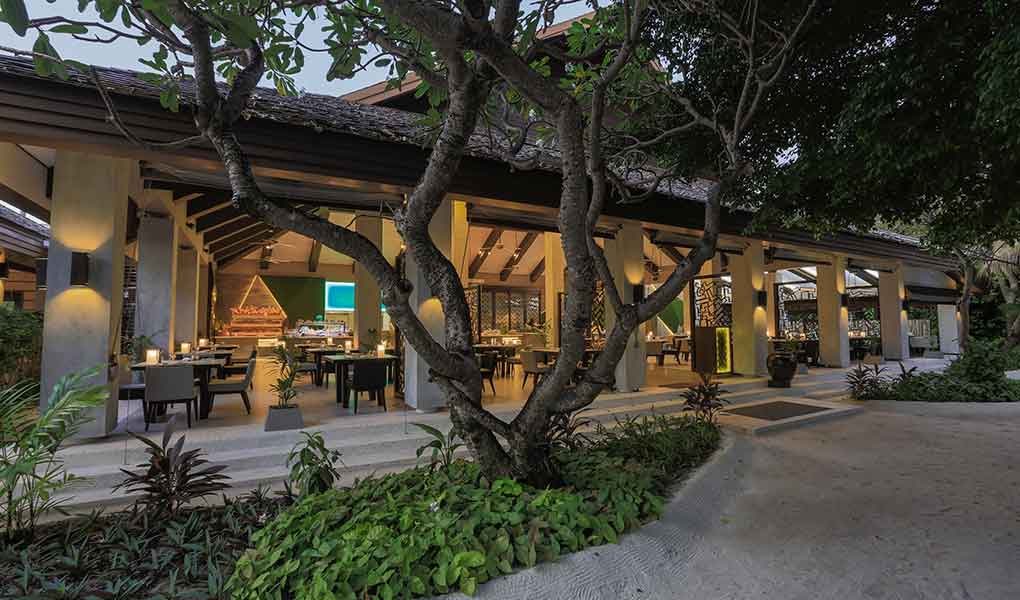 Restaurante del hotel sobre la playa de Maldivas con iluminación nocturna