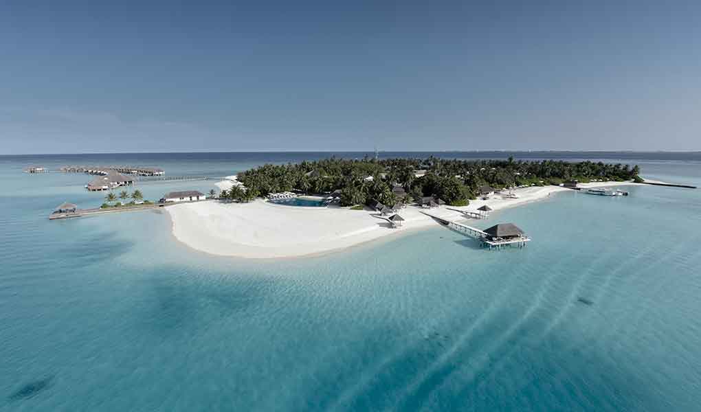 Imagen de la isla del hotel desde lejos mar de Maldivas y arrecifes de coral