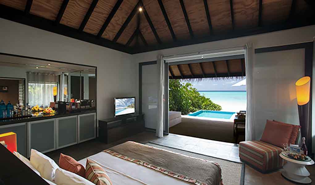 Vistas desde el interior de la villa a la piscina privada y el mar en Maldivas