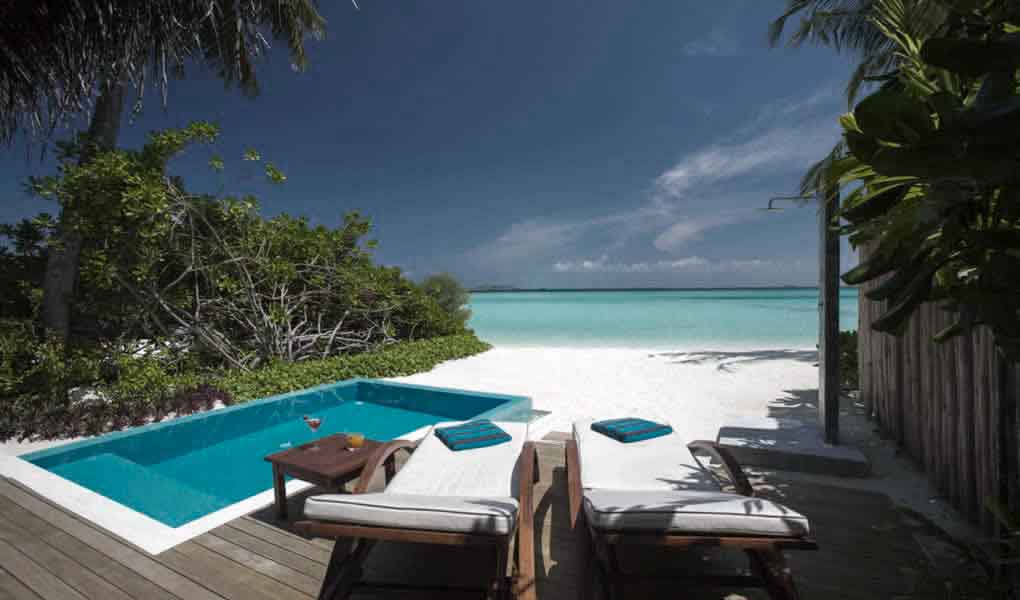 Vistas desde el interior de la villa a la piscina privada y el mar en Maldivas