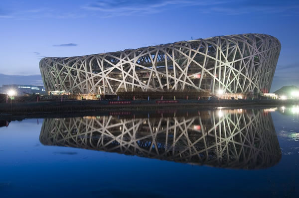Edificio futurista en China con reflejo sobre un río al atardecer.