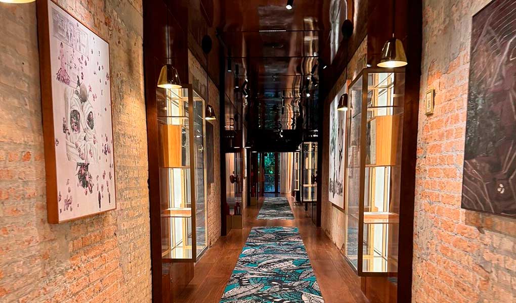 Pasillo a las habitaciones del hotel con obras de arte