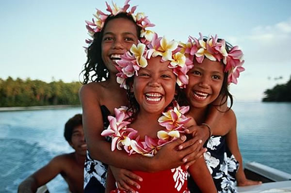 Personas en una canoa en Islas Cook con adornos con flores 