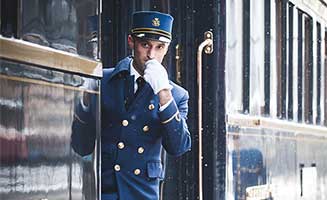 Tren de lujo Venice Simplon Orient Express con persona avisando embarque