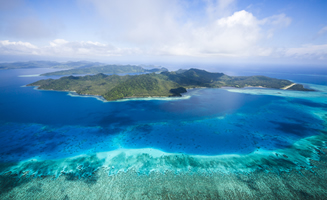 Vistas aéreas de islas de Fiji con mar en diferentes colores de azules y turquesa.