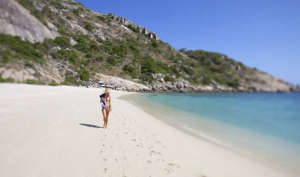 Mujer caminando por la playa en Lizard Island Australia.