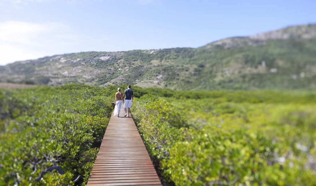 Pareja caminando sobre pasarela de madera en Lizard Island.