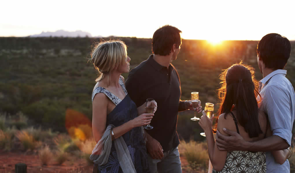 Grupo de personas al atardecer en Ayers Rock en lodge Longitude 131