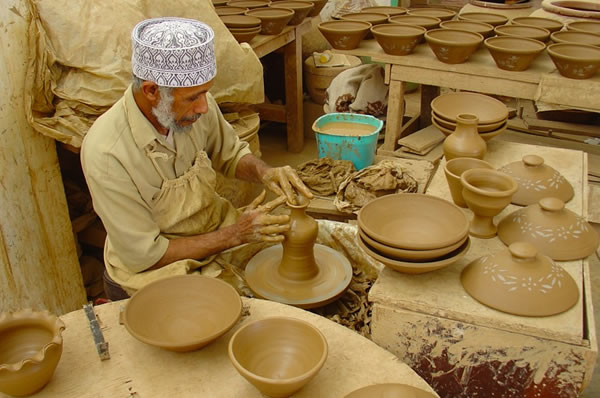 Artesano trabajando en Nizwa mercado cerámica Omán