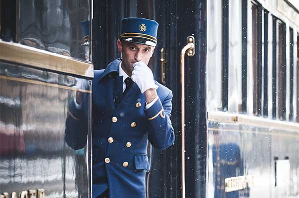 Personal del tren Venice Simplon Orient Express frente azul y uniforme tradicional