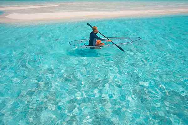 Una persona haciendo Kayak en Maldivas aguas transparentes