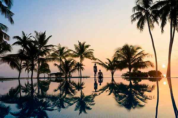 Atardecer en las zonas del hotel con palmeras y la piscina
